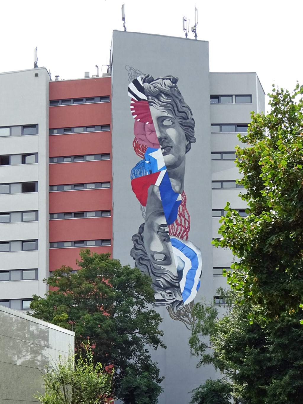 Mural an Studierenwohnhaus zeigt zwei Gesichtshälften im Stil antiker Skulpturen