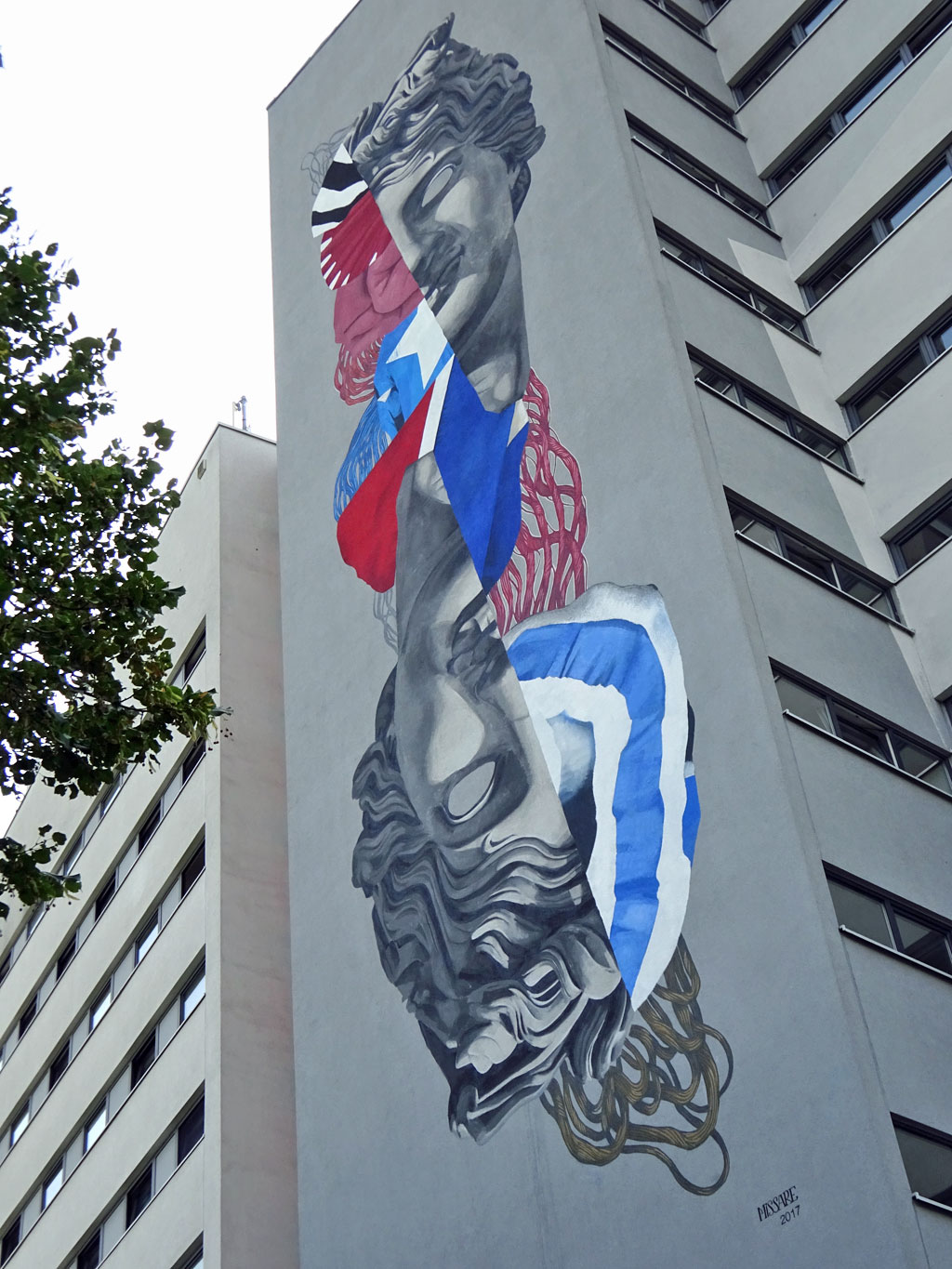Mural an Studierenwohnhaus zeigt zwei Gesichtshälften im Stil antiker Skulpturen