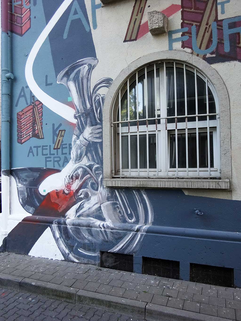Detailreiches Mural ziert Hausfassade des Atelier-Frankfurt-Gebäudes