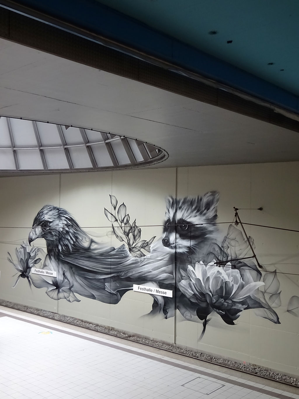 Großes Partnerstädte-Wandbild in U-Bahn-Station Festhalle/Messe in Frankfurt zeigt Adler (für Frankfurt) und Waschbär (für Toronto)