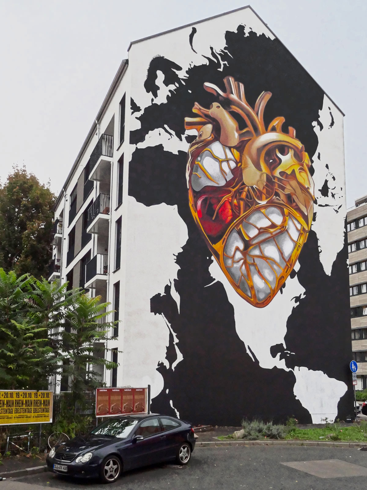 Mural in Frankfurt von Core zeigt goldenes Herz über schwarz-weißer Weltkarte