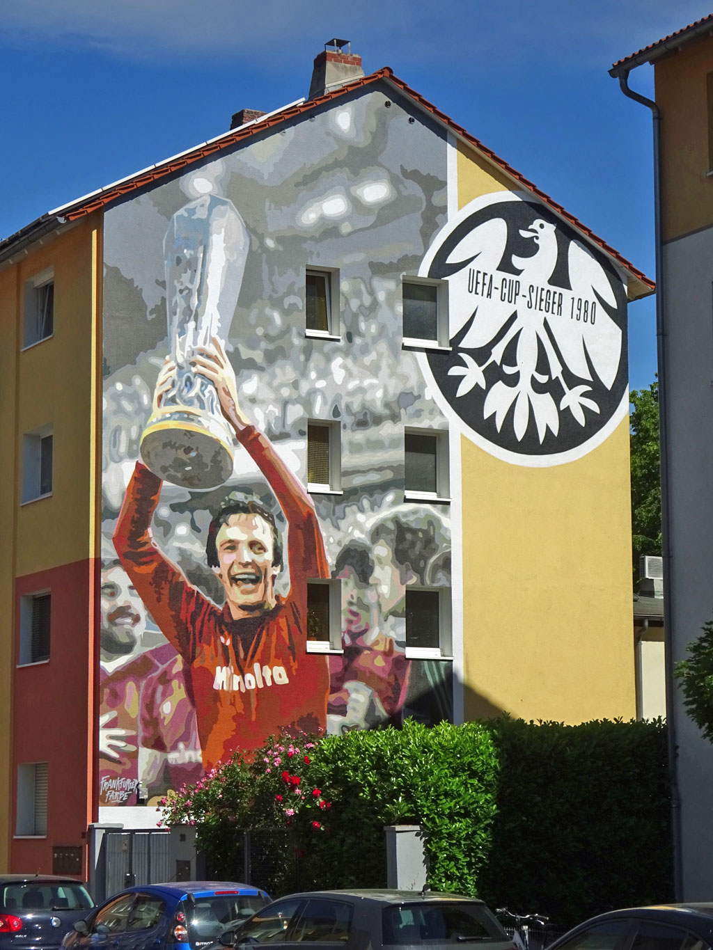 Mural mit großem Bild von Charly Körbel mit UEAFA-Cup in den Händen