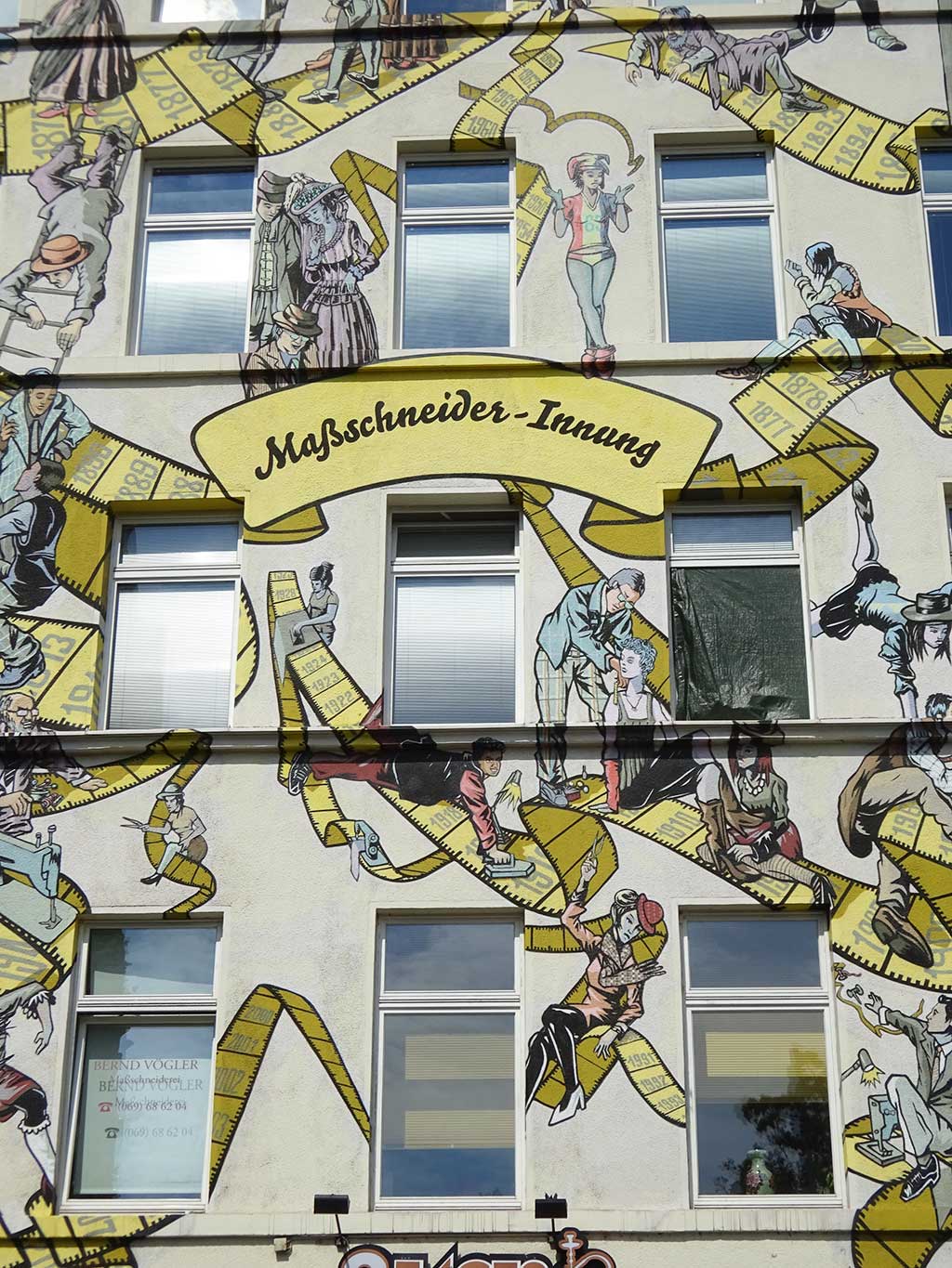 Rund 60 Figuren auf der Hausfassade illustrieren die Geschichte des Maßschneiderhandwerks sowie die Mode der jeweiligen Zeit