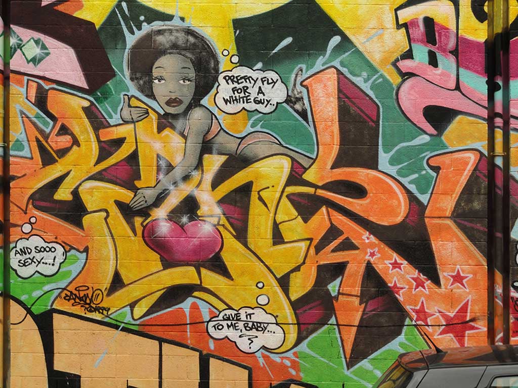 Bunte Fassadengestaltung des JUZ am Heideplatz, u. a. mit Zitaten aus Songs