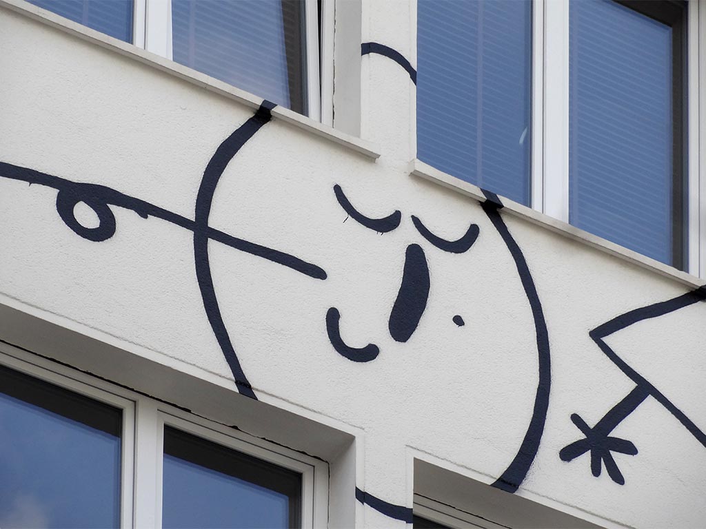 Schwarz-weiß-Illustration mit mehräugigen Gesichtern an Fassade im Bahnhofsviertel