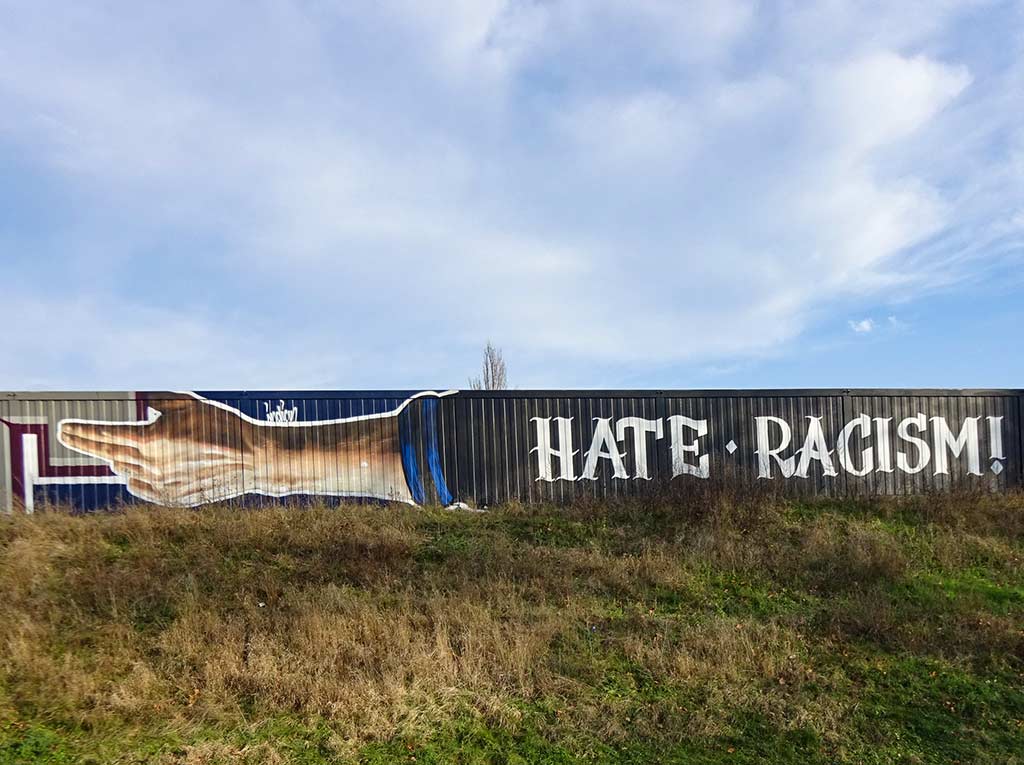 Zwei ausgestreckte Hände und dazwischen der Spruch Love Football Hate Racism